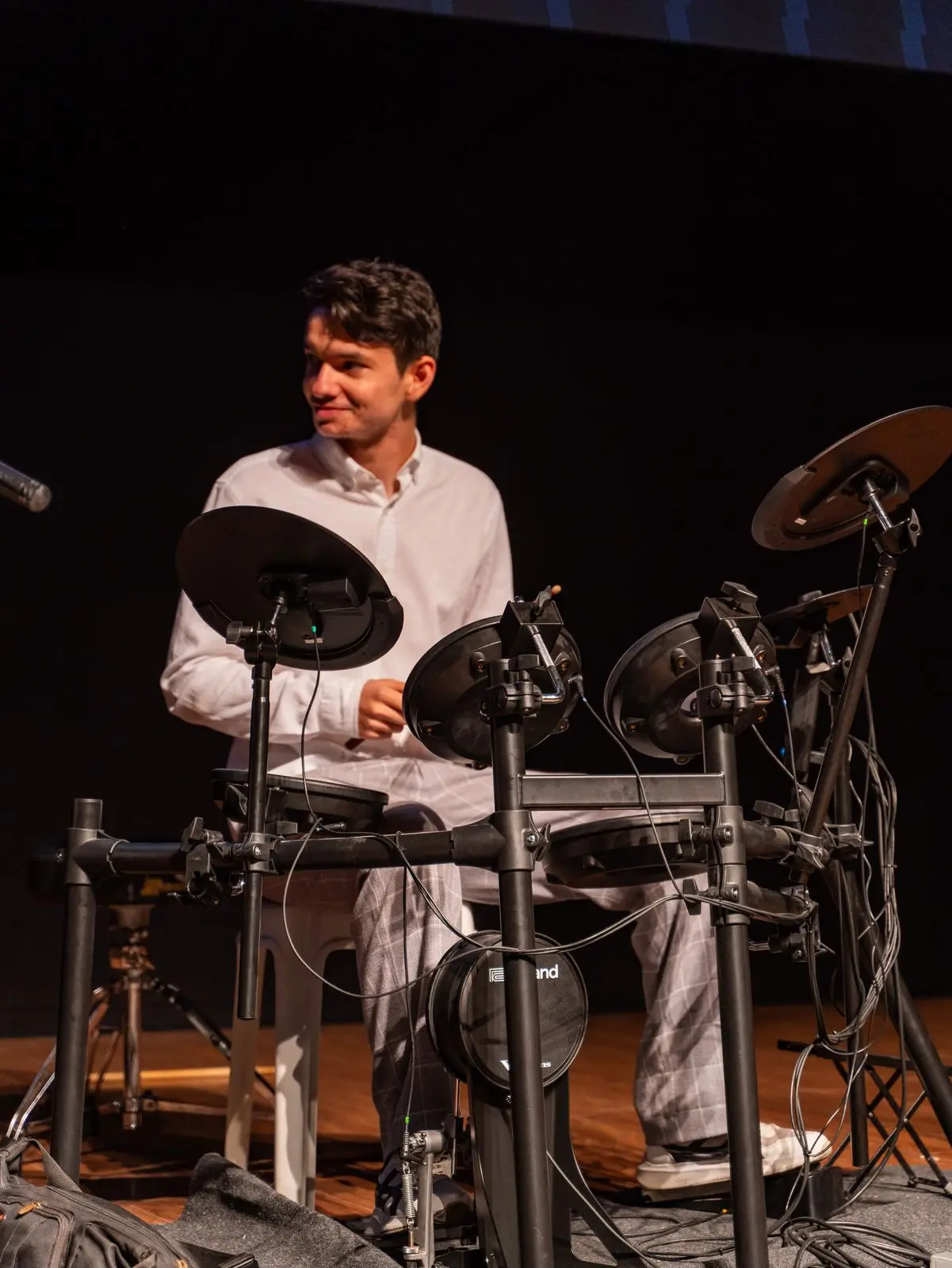 Sahnede bateri çalan genç bir öğrenci